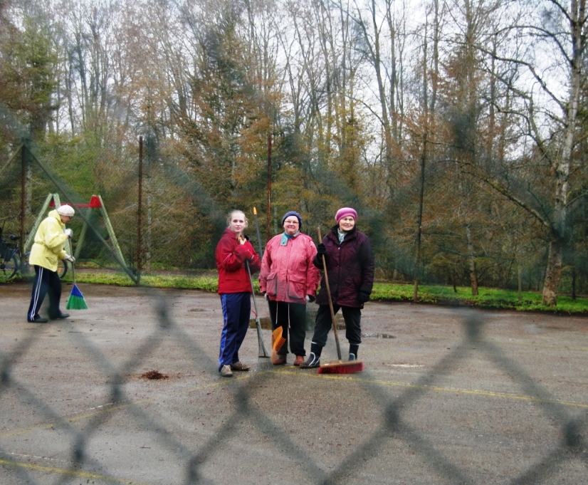 Tüdrukud tenniseplatsi puhastamas
